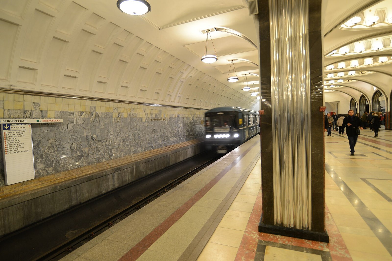 Mayakovskaya platform hall with steel columns and a train arriving